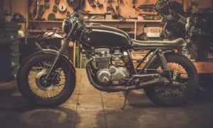 Czarny motocykl typu cafe racer w warsztacie, gotowy do sezonu.
