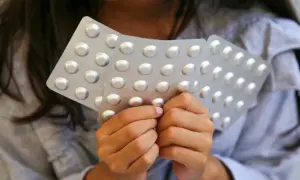 Dziecko trzyma blistry z tabletkami, być może z lekiem takim jak Ritalin.