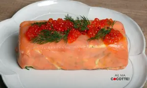 Une délicieuse terrine de saumon, garnie de perles rouges et d'aneth frais, prête à être dégustée.