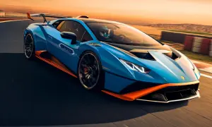 Niebieski Lamborghini Huracan STO z pomarańczowymi akcentami pędzi po torze wyścigowym podczas zachodu słońca.