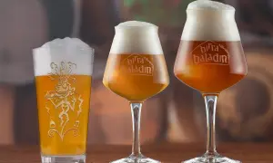 Tre bicchieri di birra, uno tipo pinta americana, con schiuma abbondante e logo Baladin inciso.