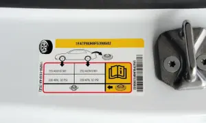 Naklejka informuje o prawidłowym ciśnieniu w oponach: 220 KPA, 32 PSI.