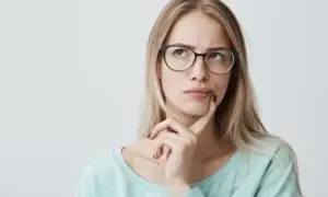 Mujer pensativa con gafas, dudando si "hice" o "hize" es correcto.