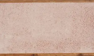 Superficie in coccio pesto con venature rosse, incorniciata da listelli di legno grezzo.