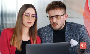 Para dyskutuje o tym, czy okulary ochronne psują wzrok, patrząc na laptopa.