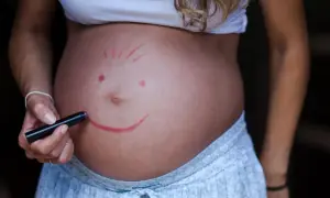 Brzuch ciężarnej z namalowaną buźką. Czy dziecko w brzuchu czuje, że jest niechciane? Nie, ta buźka mówi "kocham Cię".