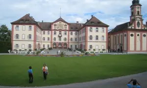 Mainau slott med sitt imponerande torn och vackra trädgårdar. En solig dag med moln på himlen.