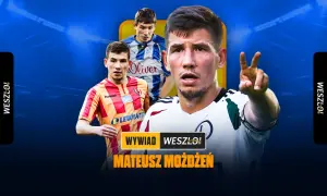 Mateusz Możdżeń w białej koszulce z zielonymi akcentami pokazuje dwa palce. W tle dwaj inni piłkarze w żółto-czerwonych i niebiesko-białych strojach.