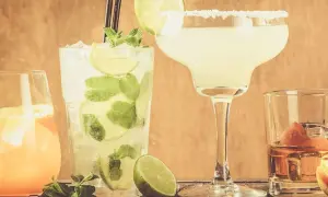 Fyra klassiska drinkar: en mojito, en margarita med saltkant, en orange drink och en whisky med apelsinskal.