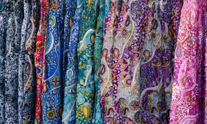 Bunte Stoffe mit Paisley-Muster, wie sie für Popeline typisch sind, hängen nebeneinander.