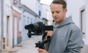 Mężczyzna z kamerą Sony Alpha 7 na stabilizatorze DJI Ronin S2. Zastanawiasz się, który aparat fotograficzny wybrać?