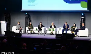 Panel dyskusyjny z udziałem ekspertów na scenie, siedzących na białych sofach.