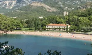 Piękne czarnogóra plaże z turkusową wodą, piaszczystym brzegiem i luksusową willą w tle.