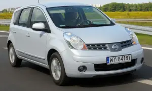 Srebrny Nissan Note E11 w ruchu drogowym. Kierowca w czapce prowadzi auto po asfaltowej drodze.