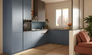 Cucina moderna con mobili blu, forno a incasso e un'area living con divano arancione. I mini case interni sono ben integrati nel design.