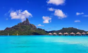 Bora Bora: idealna pogoda, turkusowa woda, góry i domki na wodzie.