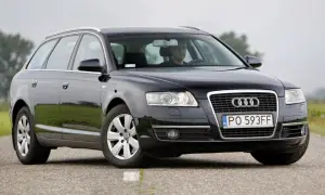 Audi A6 C6 kombi, przygotowanie do wymiany żarówki do jazdy dziennej. Kierowca w kabinie.