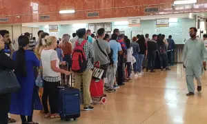 Kolejka podróżnych w hali odlotów, być może na lotnisku AUH Zayed International, oczekujących na odprawę.