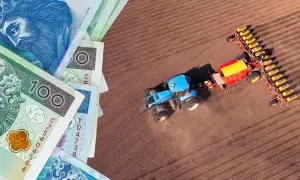 Pieniądze i niebieski traktor z siewnikiem na polu. Czy to symbol rolnictwa i podatku rolnego?