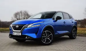 Niebieski Nissan Qashqai e-POWER na brukowanej nawierzchni. Wiele osób szuka nissan qashqai opinie przed zakupem.