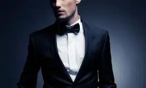 Ein Mann im eleganten Anzug mit Fliege. Der Smoking-Stil unterstreicht seine maskuline Ausstrahlung.