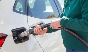 Tankowanie samochodu CNG i hybryda: co to za paliwo? Dłoń trzyma pistolet do tankowania gazu ziemnego.