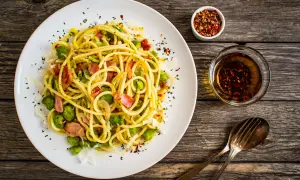 Pyszny makaron z bobem, chrupiącym boczkiem i parmezanem, podany z oliwą i płatkami chili. Idealny na szybki obiad.