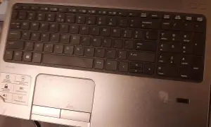 Klawiatura laptopa HP ProBook z widocznym touchpadem i naklejkami.