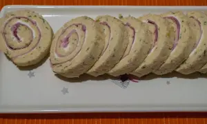 Un roulé au jambon fromage, coupé en tranches, garni de fromage frais et de fines herbes. Parfait pour un apéritif.
