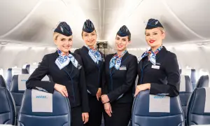 Uśmiechnięte stewardessy Enter Air w granatowych mundurach, gotowe do obsługi lotów czarterowych.