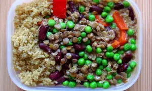 En näringsrik vegetarisk matlåda med quinoa, linser, bönor, ärtor och paprika. Perfekt för en hälsosam lunch!