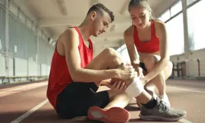 Kontuzja podczas biegania? Ona opatruje mu nogę. Może to wpłynąć na jego plan treningowy bieganie.