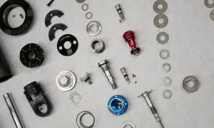 Rozłożone części do serwisu amortyzatorów rowerowych. Precyzyjne elementy gotowe do montażu.