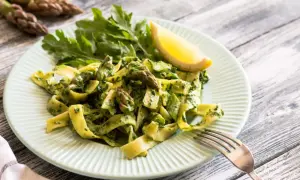 Pappardelle ze szparagami i zielonym pesto, udekorowane rukolą i cytryną. Pyszne danie, które zachwyci każdego miłośnika makaronu.
