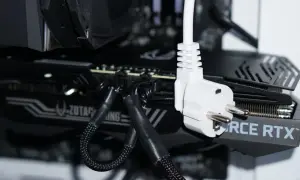 Nahaufnahme eines Gaming-PC-Netzkabels, das in eine Grafikkarte eingesteckt ist. Der Stromverbrauch ist hier ein wichtiges Thema.