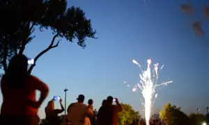 Gente observa fuegos artificiales, como en las mejores ferias de España.