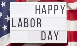 Cartel luminoso con "HAPPY LABOR DAY" sobre bandera de EE.UU. Celebrando el día del trabajador en inglés.