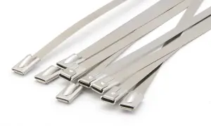 Kilka metalowych trytytek leży obok siebie na białym tle.