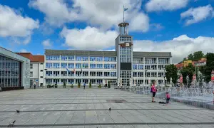 Plac miejski w Koszalinie, stare miasto, z ratuszem i fontannami w tle.