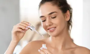 Une femme applique un sérum à la vitamine A rétinol pour une peau éclatante.