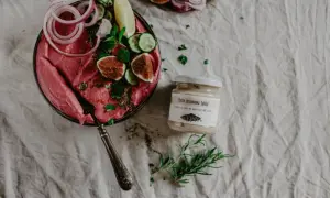 Różowa pasta z buraków z figami i ogórkiem, obok słoiczek z pastą sezamową tahini – idealna do sosów i dipów.