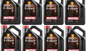 Cztery czarne kanistry oleju silnikowego Motul 8100 X-clean+ SAE 5W30 z czerwonymi nakrętkami.