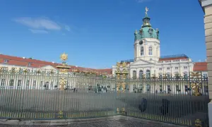 Zamek Charlottenburg, cel jednodniowej wycieczki z Poznania. Złote zdobienia bramy i błękitne niebo.