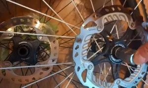 Dwa hamulce tarczowe rowerowe, jeden z mocowaniem center lock Shimano, drugi z mocowaniem center lock DT Swiss.