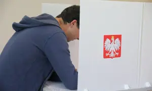 Młody mężczyzna w budce wyborczej, z orłem na ścianie. Czy to symbol jego wyboru, dlaczego młodzi mężczyźni tak chętnie głosują na Konfederację?