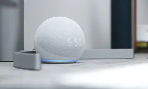 Altavoz inteligente blanco con luz azul, mostrando la hora. Descubre todo lo que puede hacer Alexa para simplificar tu día.