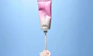 Tube de scrub rose et blanc Madame D'Alexis, produit pour un detox cuir chevelu, avec une texture crémeuse qui s'écoule.