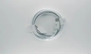 Biały kabel z końcówkami USB-C, zgodny ze standardem USB C, zwinięty na białym tle.