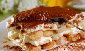 Un tiramisu crémeux, saupoudré de cacao. Pour un goût optimal, demandez-vous combien de temps laisser reposer un tiramisu au frigo.
