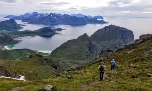 Widok na górzysty archipelag z turystami wędrującymi po zboczu.